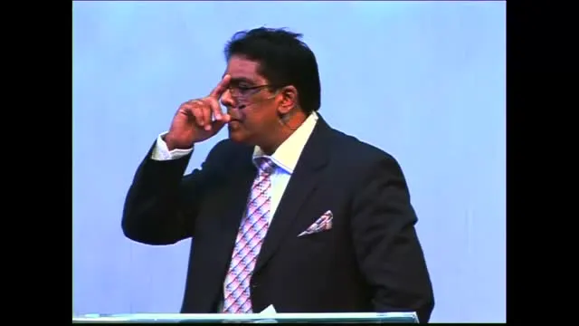 Dr RJ Sing preaching in a dark suit and patterned tie, 2010